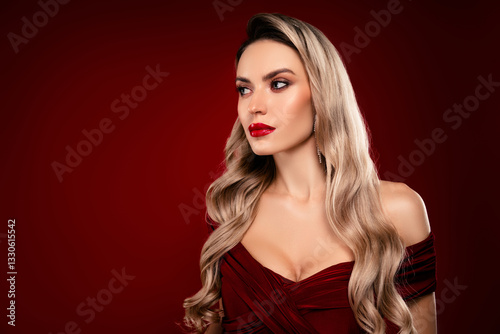 Glamorous blond woman in elegant burgundy evening dress against a deep red background