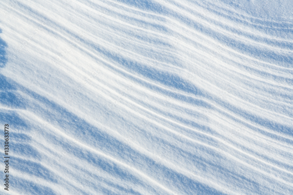 Beautiful winter background with snowy ground. Natural snow texture. Wind sculpted patterns on snow surface.