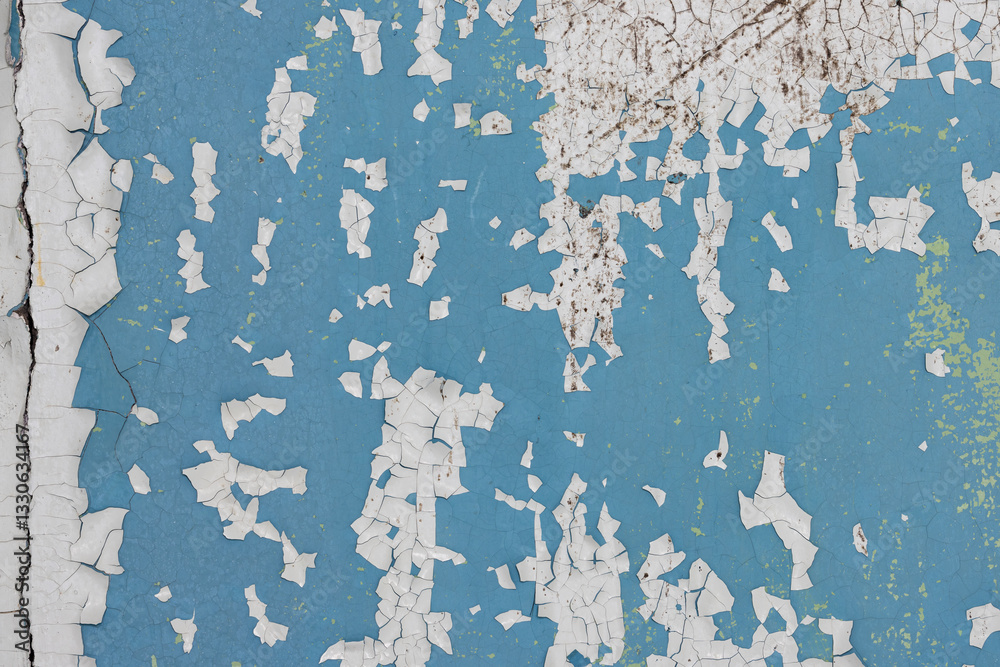 Peeling paint on the wall. Old concrete wall with cracked flaking paint. Weathered rough painted surface with patterns of cracks and peeling. High resolution texture for background and design. Closeup