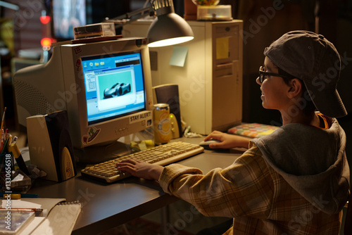 Young person sitting at desk using vintage computer in bedroom. Retro-style gaming scene with cluttered desk and focused expression. Capturing nostalgic vibe with warm lighting