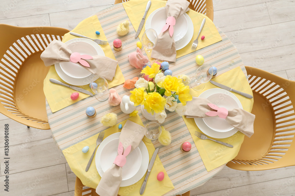 Fototapeta premium Beautiful table setting with flowers and Easter eggs in dining room