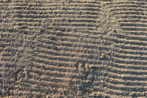 Textured soil showing distinct patterns from recent cultivation on a sunny afternoon