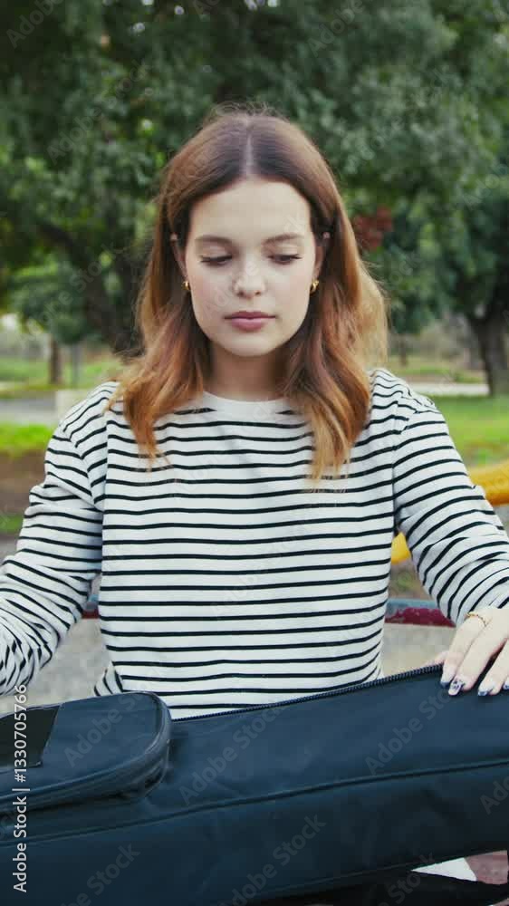 Girl Puts The Musical Instrument Ukulele In The Case Outdoor In Park Girl Puts The Musical Instrument Ukulele In The Case Outdoor In Park