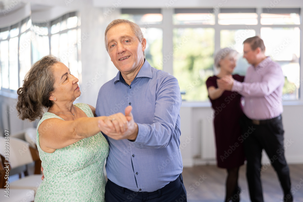 Obraz premium Senior man and elderly woman are dancing classic version of waltz in couple during lesson at studio. Leisure activities and physical activity for positive people.