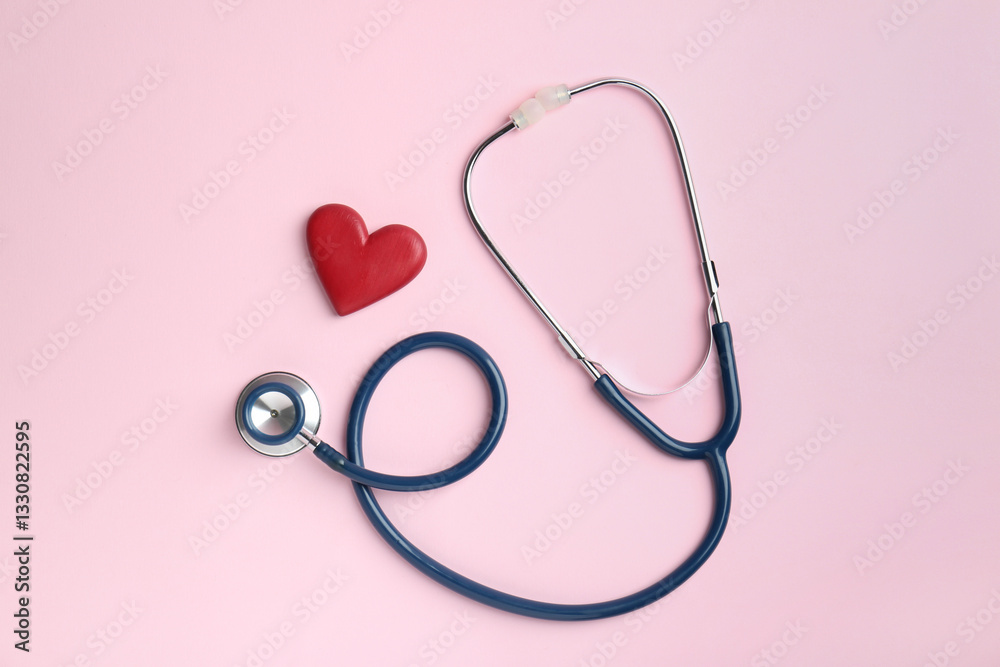 Cardiology. Stethoscope and red decorative heart on pale pink background, flat lay Cardiology. Stethoscope and red decorative heart on pale pink background, flat lay