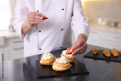 Professional pastry chef making desserts at table in kitchen, closeup