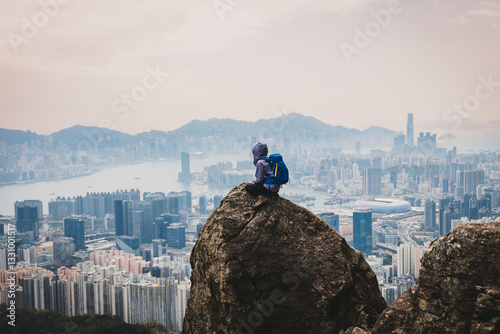 Canvas Print Woman traveller sit on the cliff edge enjoy the beautiful view of hong kong