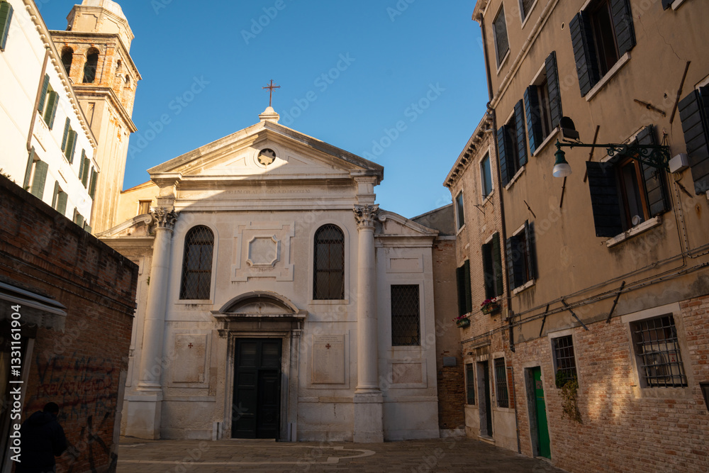 Fototapeta premium A charming historic church in Venice, Italy, surrounded by old buildings in a quiet square.