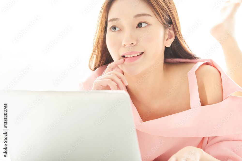 A young and beautiful woman is enjoying a pleasant holiday, lying on the bed in a sun-filled bedroom while using a laptop.
A young and beautiful woman is enjoying a pleasant holiday, lying on the bed in a sun-filled bedroom while using a laptop.
