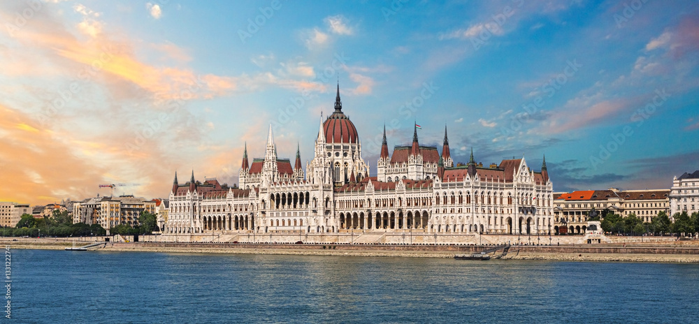 Obraz premium Hungarian parliament building reflecting on danube river at sunset in budapest