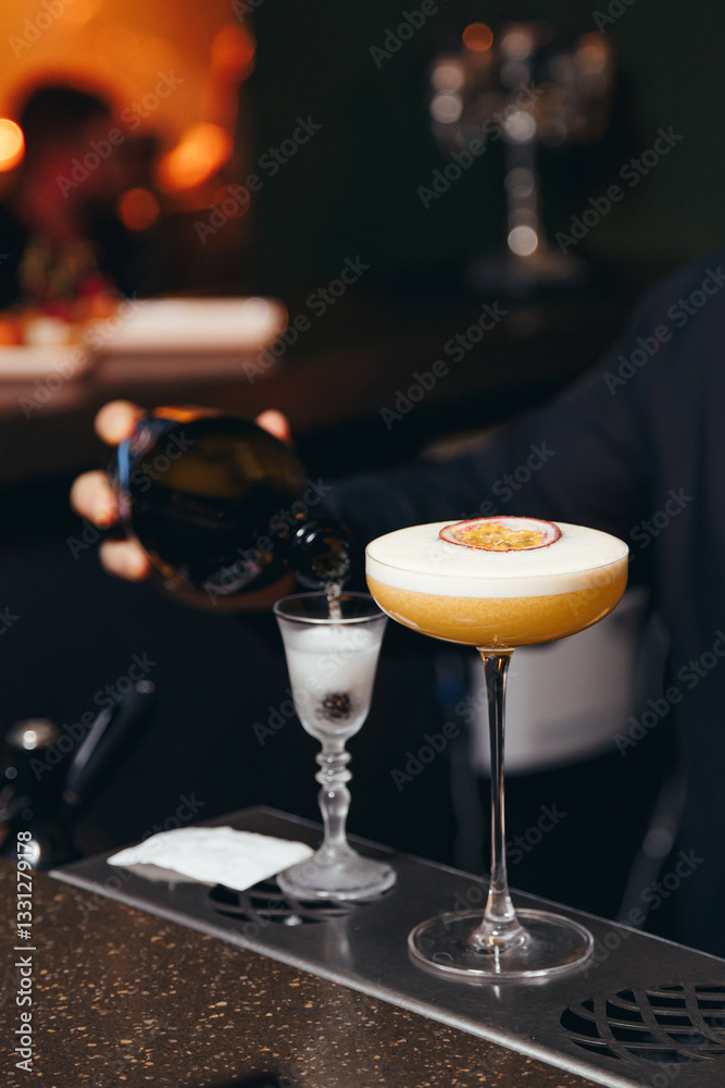 sweet and sour refreshing cocktail decorated with passion fruit on the bar counter