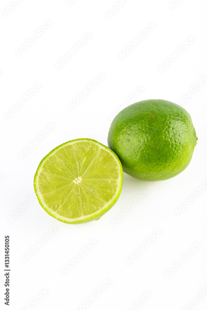 Green lime together with half a lime on white background. Copy Space. Fruit and healthy eating concept Green lime together with half a lime on white background. Copy Space. Fruit and healthy eating concept