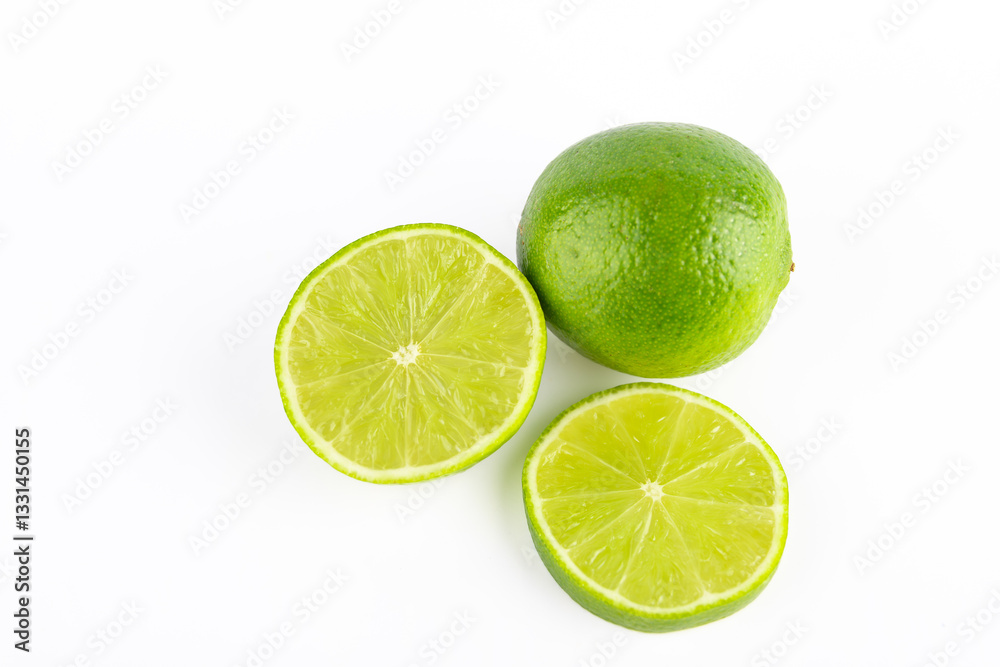 Top view of half a green lime, next to a whole lime and a juicy lime slice, isolated on white background. Copy space. Concept of fruit and healthy eating Top view of half a green lime, next to a whole lime and a juicy lime slice, isolated on white background. Copy space. Concept of fruit and healthy eating