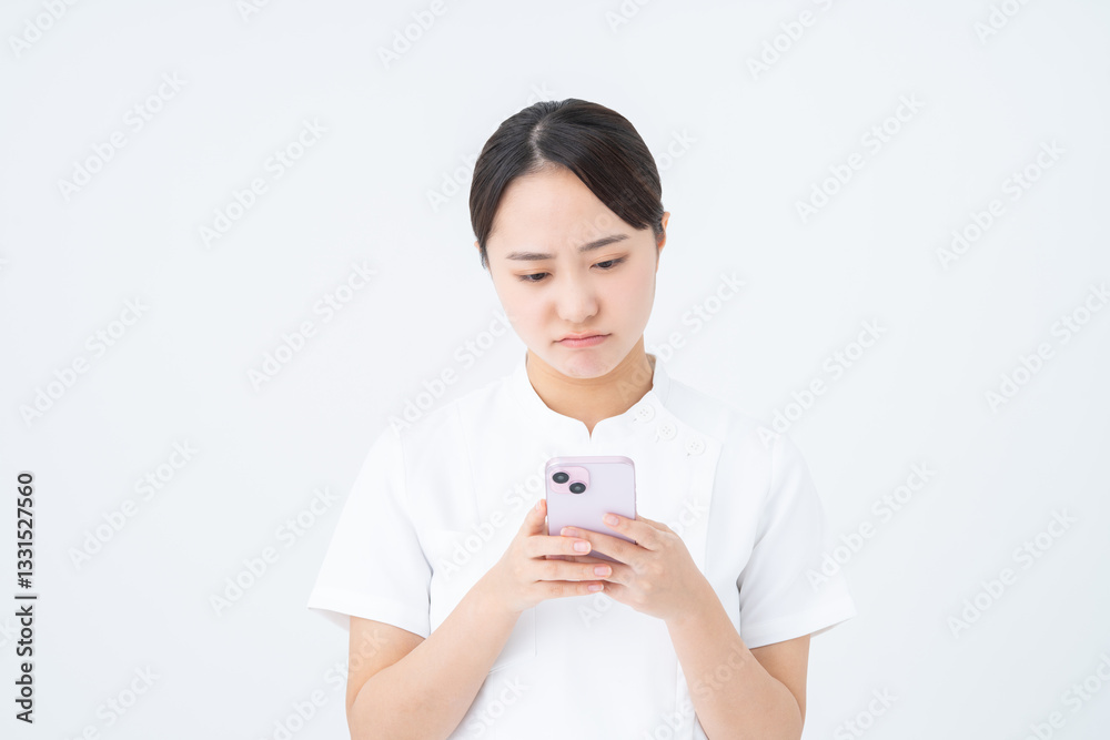 スマホを使う看護師の若い女性 スマホを使う看護師の若い女性