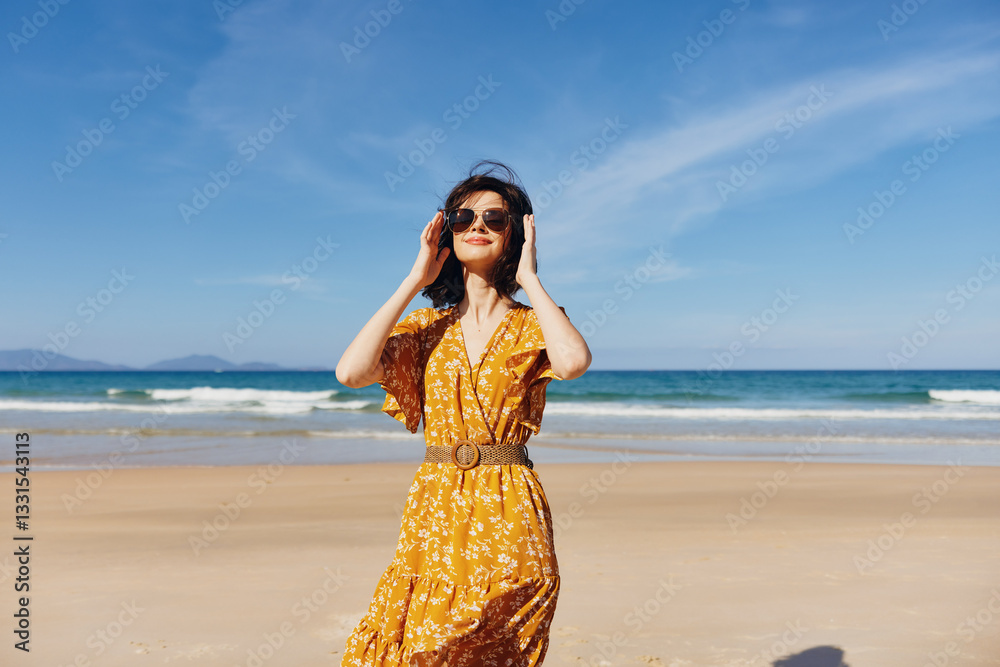 Woman in Yellow Dress Standing on Beach with Hands on Head Enjoying the Ocean View Woman in Yellow Dress Standing on Beach with Hands on Head Enjoying the Ocean View