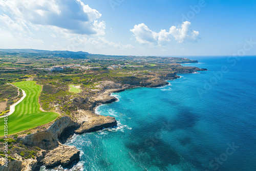 Breathtaking aerial view of secret valley golf course meeting the mediterranean sea in cyprus