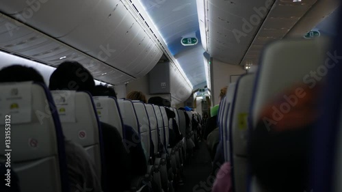 interior inside airplane aeroplane's cabin aisle while flying with shaking turbulence while fly through rough weather windy situation.emergency situation on the airplane while operating