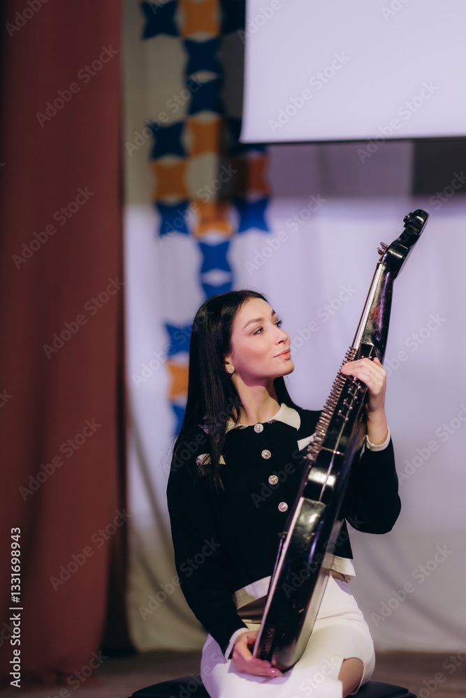 Young Woman Holding String Instrument in Artistic Indoor Setting Young Woman Holding String Instrument in Artistic Indoor Setting