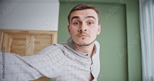 A cheerful man is capturing a selfie in a bright and welllit room full of vibrant decor