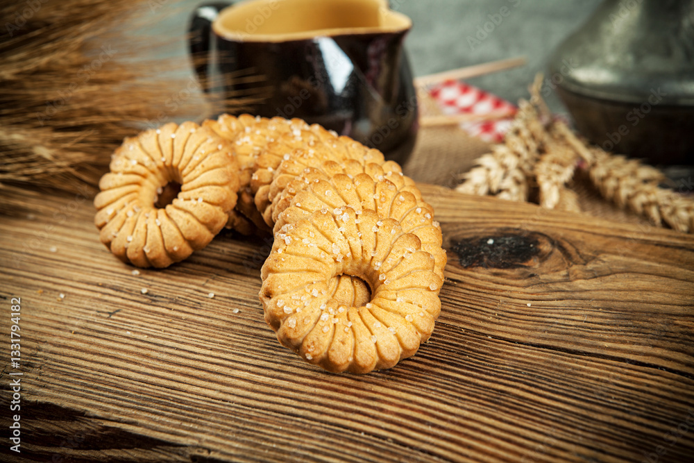 Oatmeal cookies and wheat ears on wooden table. Toned.