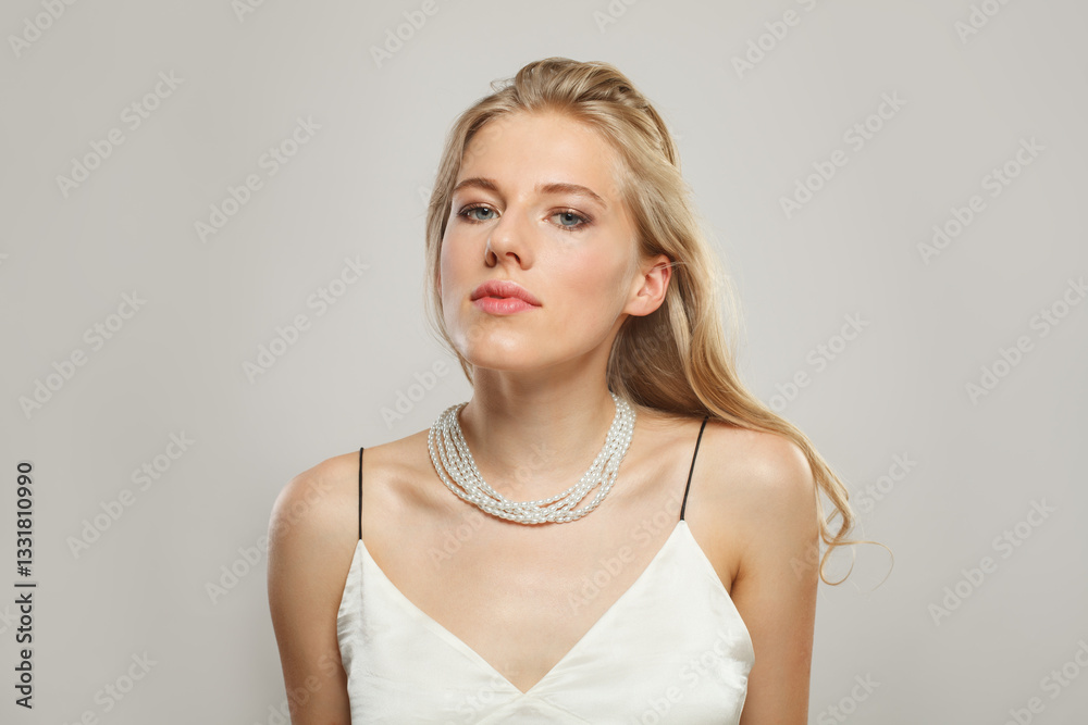 Posing blond model woman portrait. Beautiful face with healthy clear skin, long shiny hair and pearl necklace Posing blond model woman portrait. Beautiful face with healthy clear skin, long shiny hair and pearl necklace