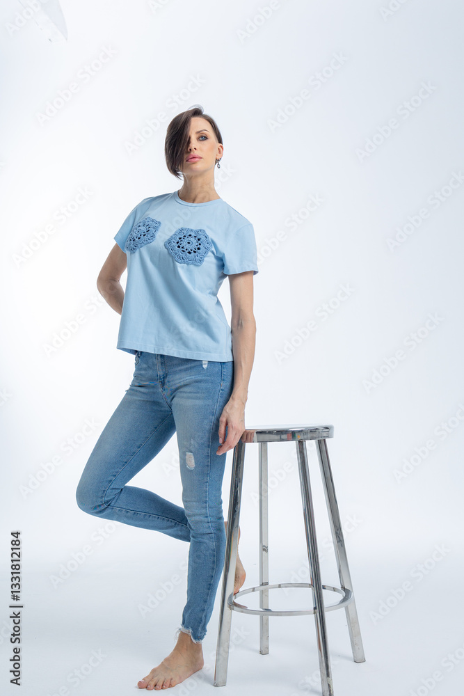 Beautiful woman of model appearance. Girl in blue clothes on grey background. Pretty female with trendy makeup posing in studio. Vertical photo. High quality photo Beautiful woman of model appearance. Girl in blue clothes on grey background. Pretty female with trendy makeup posing in studio. Vertical photo. High quality photo