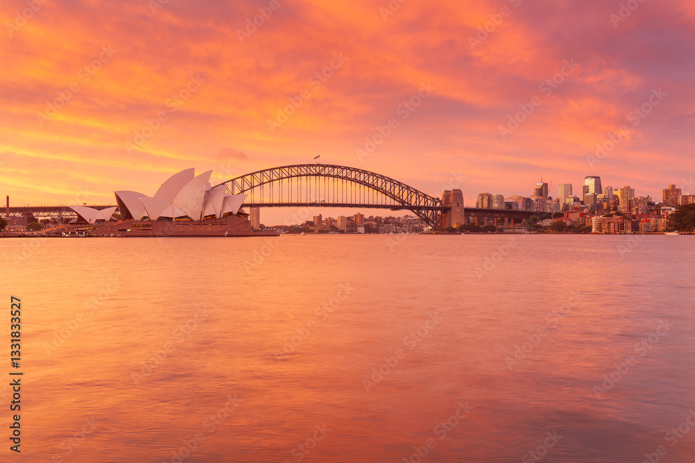 Obraz premium Sydney mit rot gefärbtem Himmel. Sonnenuntergang über der Stadt und dem Hafen von Sydney.