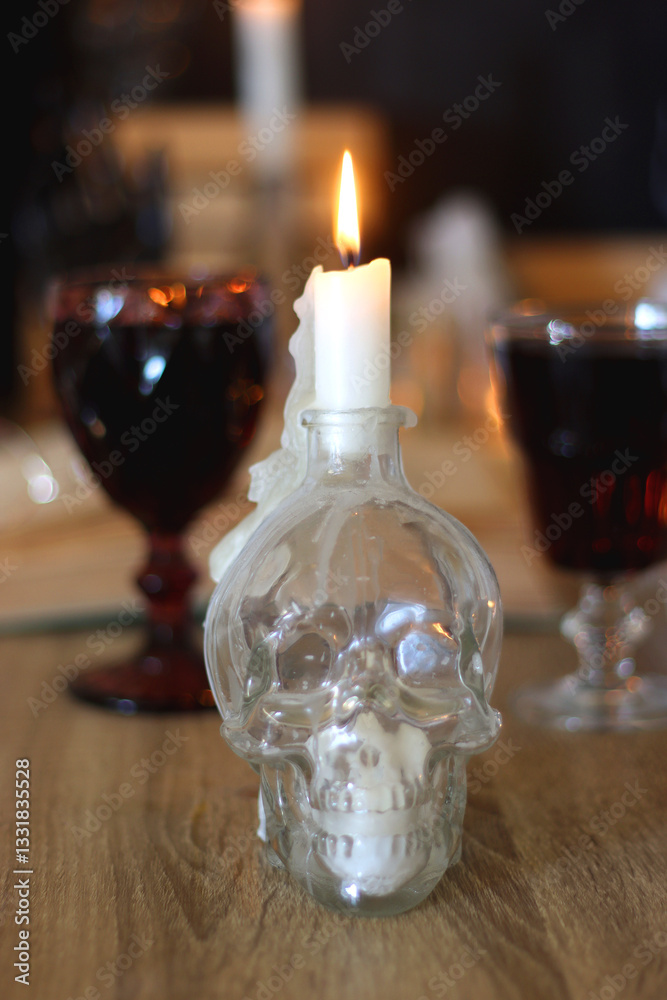 Books, lit candles, red wine, snacks and various deocration on the table. Dark academia or Halloween concept. Selective focus.