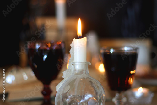 Books, lit candles, red wine, snacks and various deocration on the table. Dark academia or Halloween concept. Selective focus.