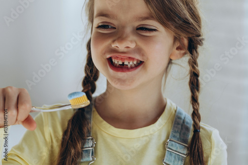 Portrait, smile and girl brushing teeth in bathroom for dental, health or oral care in her home. Happy and beautiful child in home with toothbrush brushing teeth.