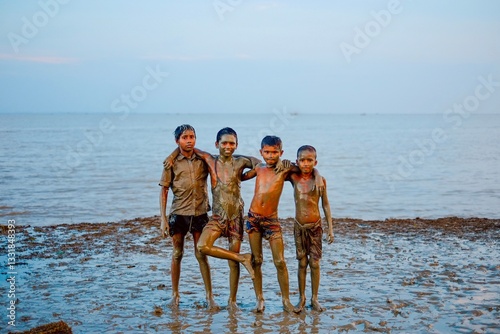 Fotografija South asian teenage boys are playing in a muddy riverside field
