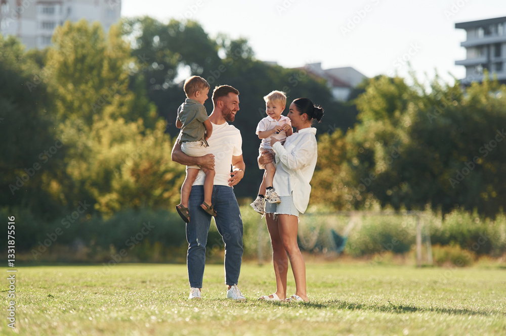 Family bonding. Mother and father are with son outdoors on the field Family bonding. Mother and father are with son outdoors on the field