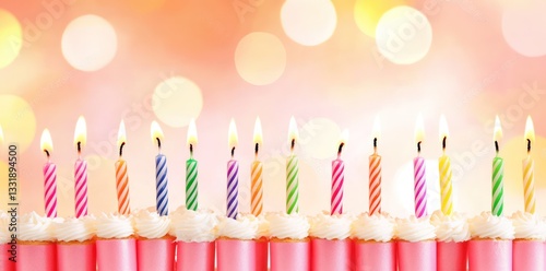 Colorful birthday candles on cupcakes, bokeh background, festive celebration