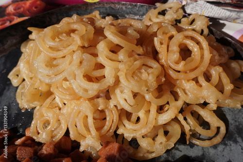 Jalebi, a popular sweet from South Asia which is made by deep-frying a fermented batter of maida flour in pretzel or circular shapes and then soaking it in sugar syrup