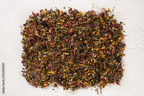 Obraz na płótnie Pile of dry herbal tea and flowers green tea on white background. View from above. Dry tea leaves texture. w salonie