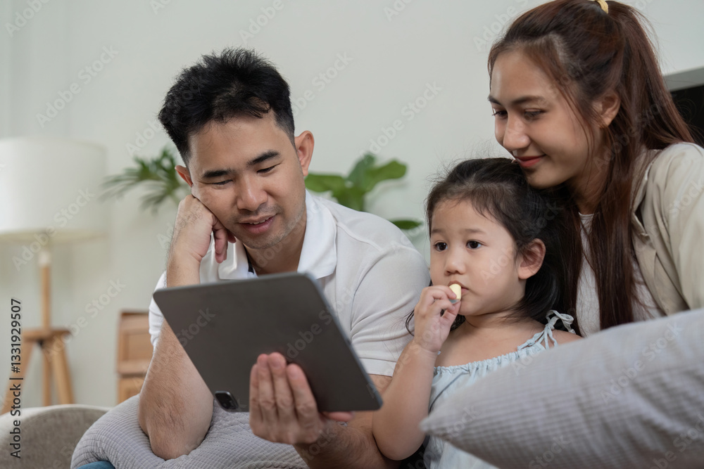 Entertainment and Family Interaction. Parents and daughter watching a tablet together, sharing popcorn and smiles. Entertainment and Family Interaction. Parents and daughter watching a tablet together, sharing popcorn and smiles.