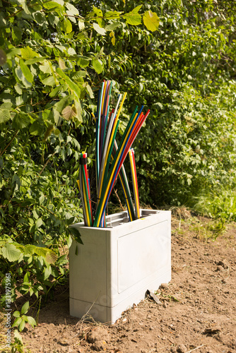 Offene Glasfaser-Verteilerbox mit bunten Glasfaser-Rohren – Breitbandausbau in Wohngebieten, modernes Telekommunikationsnetz für Highspeed-Internet und Digitalisierung.