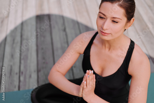 Rest after a vigorous workout with meditation. Young woman in lotus pose. Training in the open air. Young woman sitting in yoga lotus pose meditation outdoors.