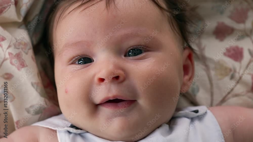 Baby lying on a patterned blanket, looking directly at the camera with a calm expression. The focus is on the baby’s facial features, capturing a moment of innocence and serenity Baby lying on a patterned blanket, looking directly at the camera with a calm expression. The focus is on the baby’s facial features, capturing a moment of innocence and serenity