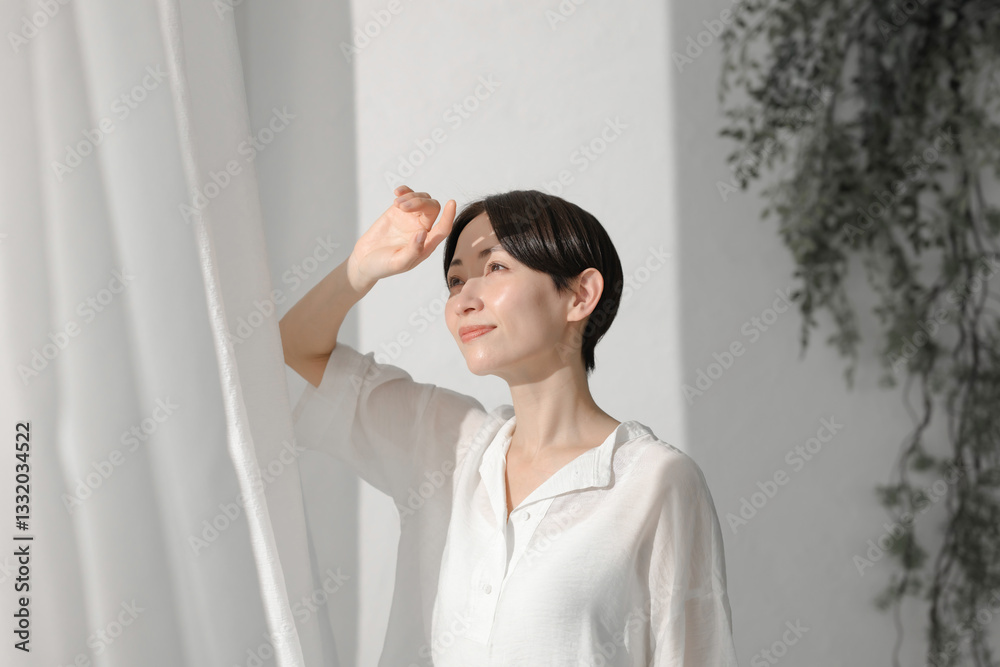 カーテンを開ける女性 カーテンを開ける女性