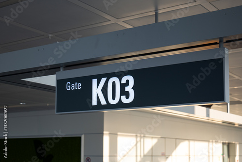 International airport ceiling mounted sign designating gate K03. Looking up shot, close up, no people