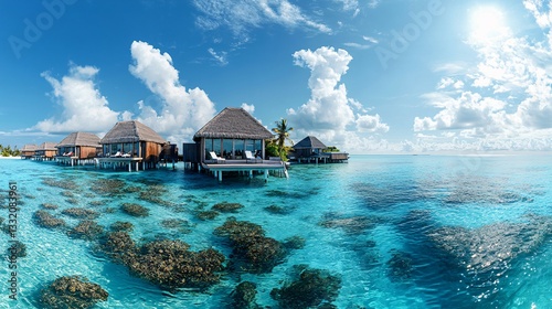 Wooden bungalows on stilts over clear turquoise tropical water