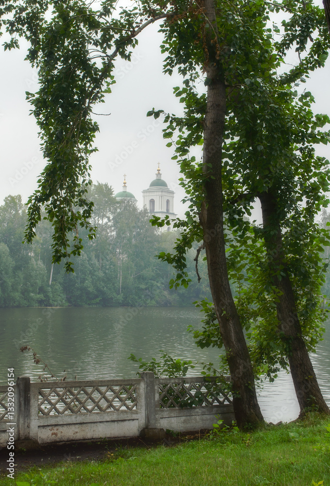 Obraz premium Kyshtym, Chelyabinsk region, Russia. Church of the Descent of the Holy Spirit on the Apostles framed by trees