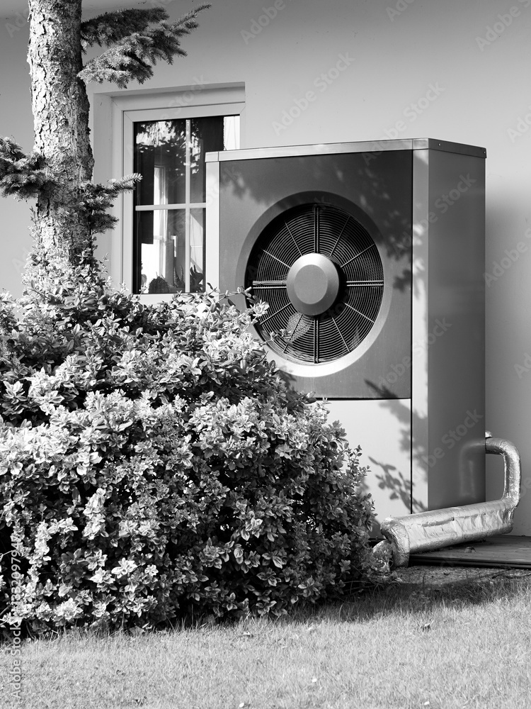 Modern house with heat pump on garden black and white, efficient heating with green energy concept