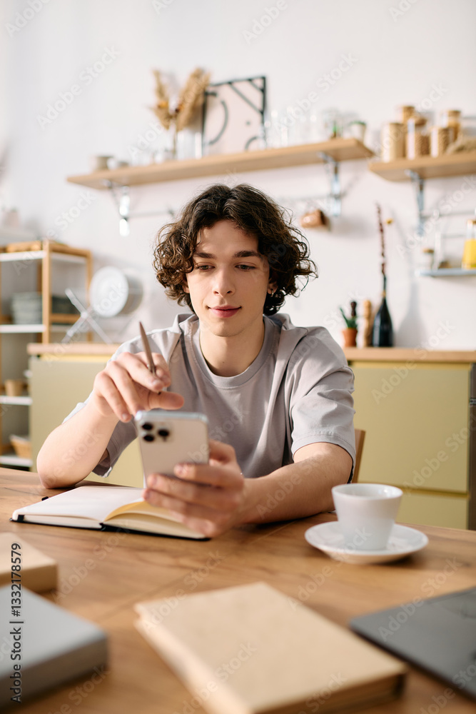 Handsome young man engaged in work while using smartphone in modern office setting Handsome young man engaged in work while using smartphone in modern office setting