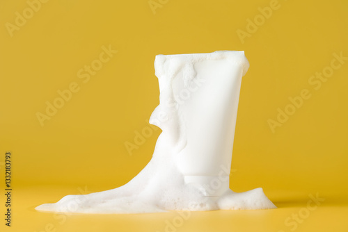 Slika na platnu Tube of cosmetic product with foam on yellow background