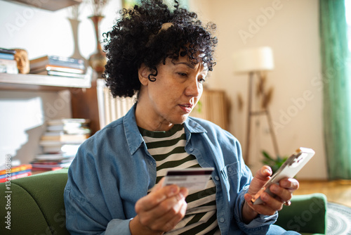 Woman shopping online with credit card and smartphone at home