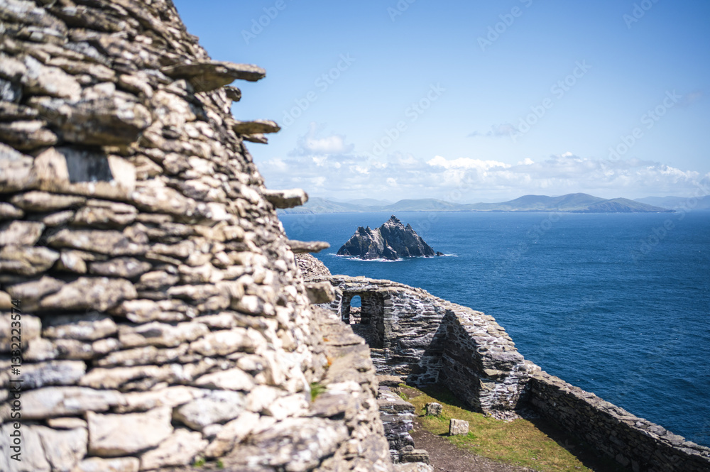 Ancient stone walls overlook Irish sea stacks. Skellig Michael