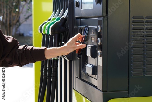 woman at the gas station holding her mobile phone up to the pump to pay or apply her app's discounts