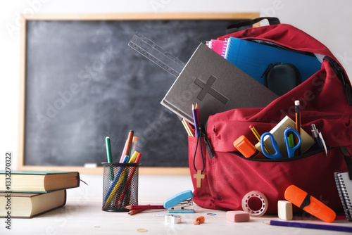 Religious education with red backpack full of tools in classroom